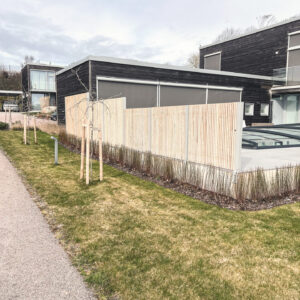 Avskärmning vid uteplats med pool. Ribbstaket med bra insynsskydd. Vindskydd i modern tappning. Silvergrå kulör och siiox behandlad träribba.